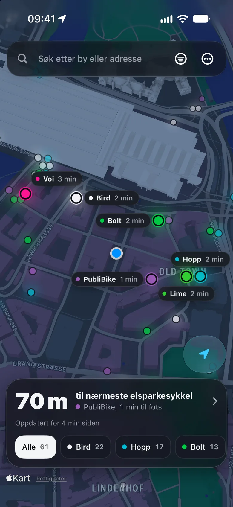 iPhone-appen om natten: de mørke gatene ved Zürich hovedstasjon, hver elsparkesykkel et lyspunkt i operatørens farge, den nærmeste fra hver operatør med navn og gangtid, og 61 elsparkesykler i bildet.